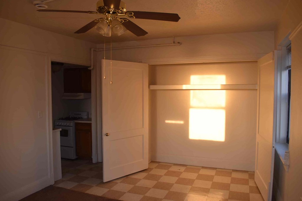 a room with a closet and a ceiling fan