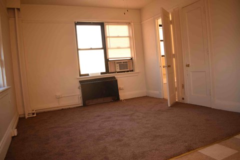 an empty living room with a fireplace and a window