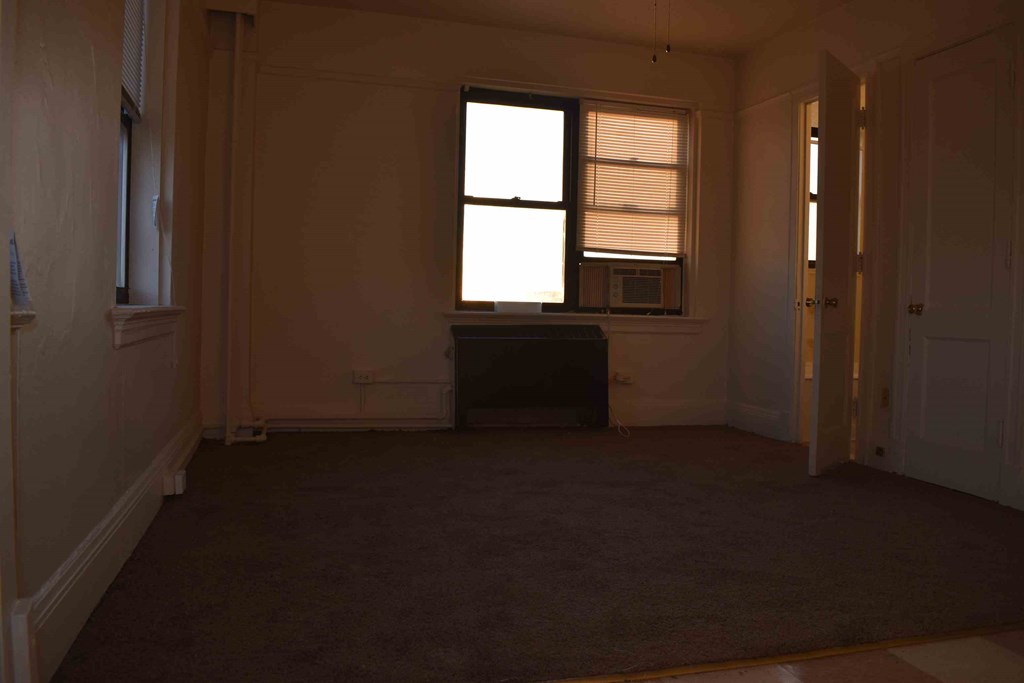 an empty room with a window and a door