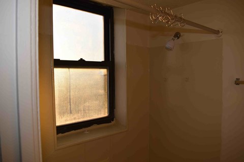 a bathroom with a window and a shower curtain