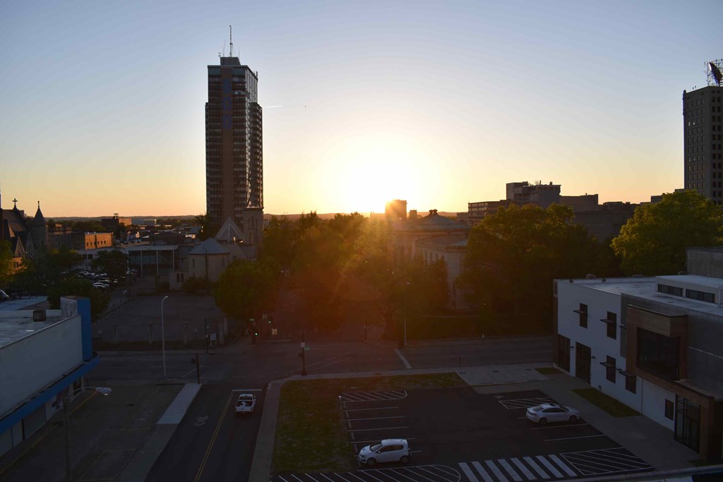 the sun setting over the city as viewed from the roof of a building