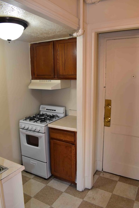 A white stove and oven in a kitchen with a checkered floor.