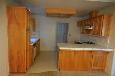 an empty kitchen with wooden cabinets and a door