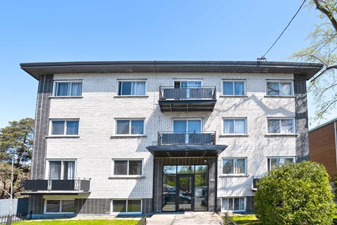 A modern building with a black gate and a balcony on the second floor.