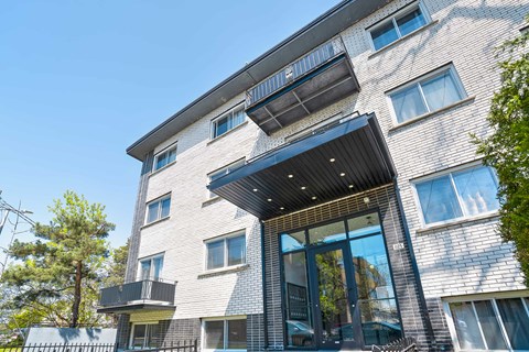 A modern building with a black awning and glass doors.