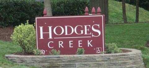 a sign for hodges creek in a garden