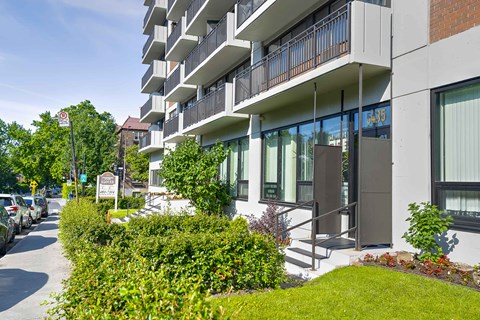 A modern apartment building with a well-maintained lawn in front.