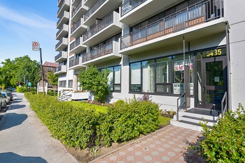 A modern apartment building with a balcony on the second floor.