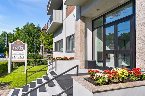 A building with a sign that says "ALOUE" and a phone number.