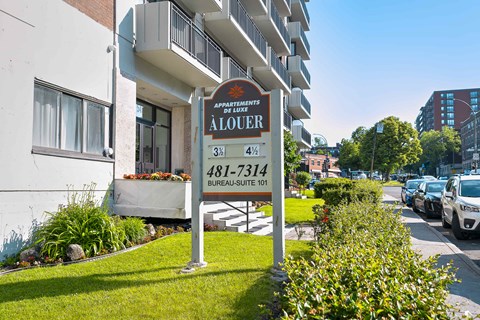 Apartment sign in front of a building.