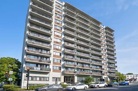 A tall residential building with balconies on each floor.