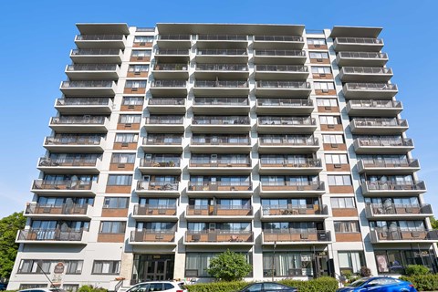 A tall residential building with balconies on each floor.