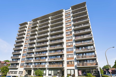 A tall residential building with balconies on each floor.