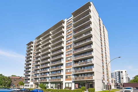 A tall residential building with balconies on each floor.