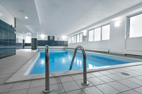 a swimming pool in a building with metal railings around it