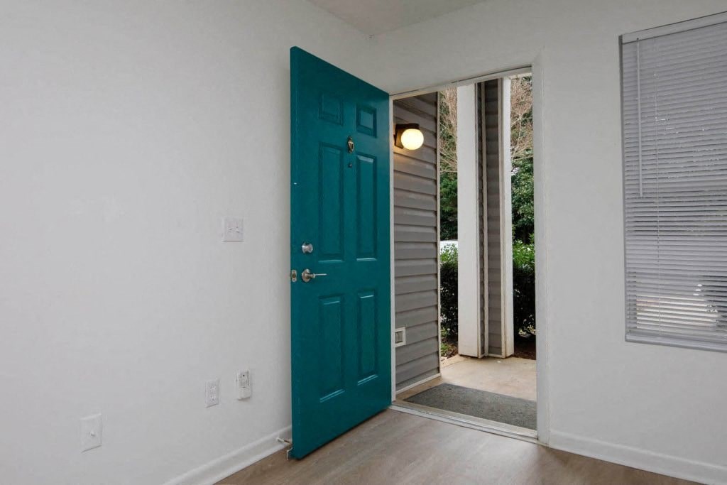 a blue door in a room with a door to the outside
