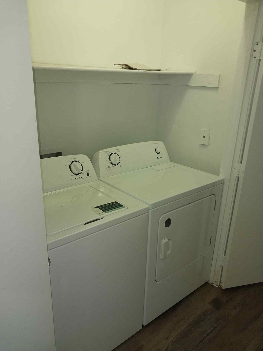 a laundry room with two washers and a dryer