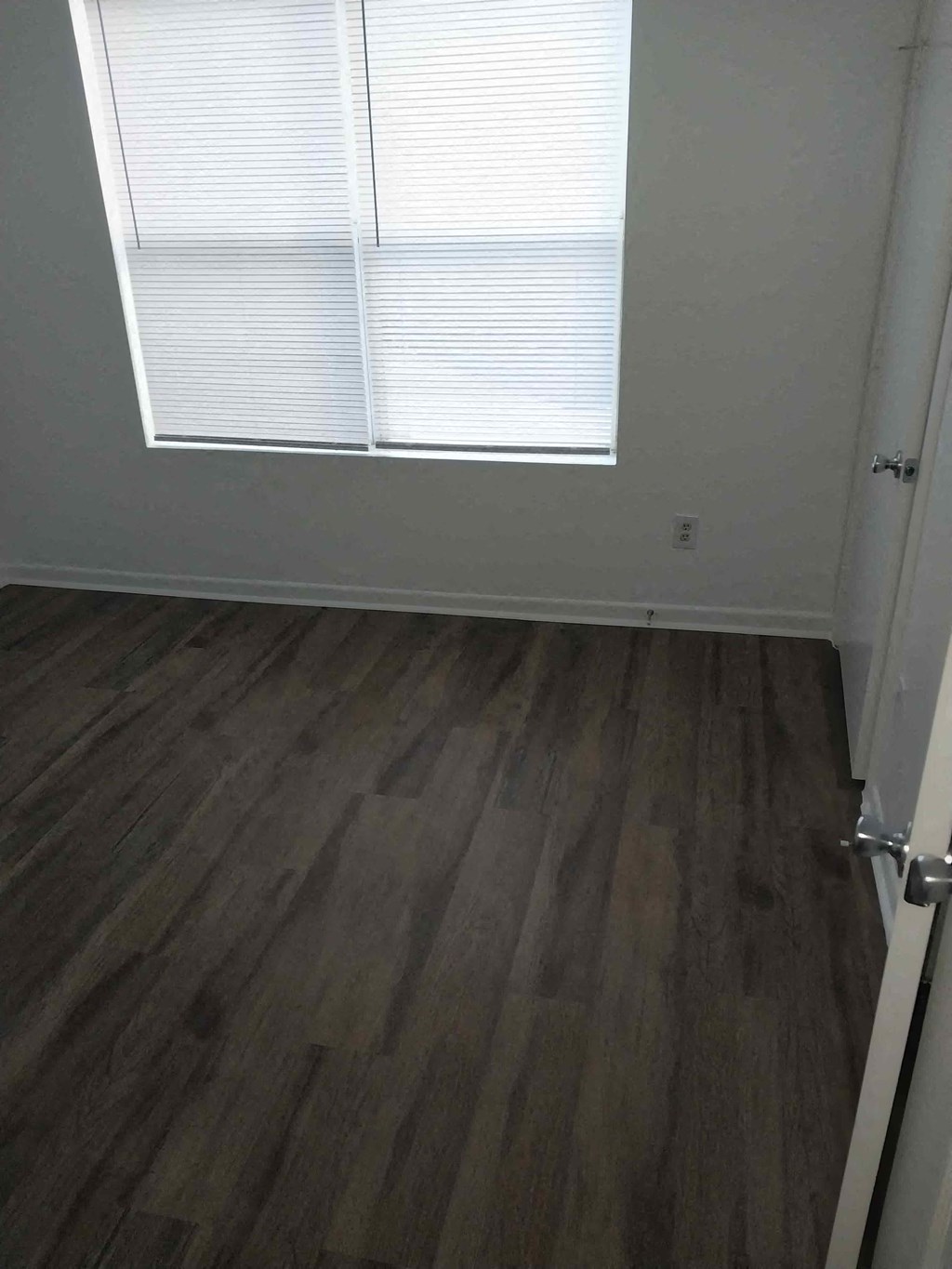 an empty room with wooden floors and a window