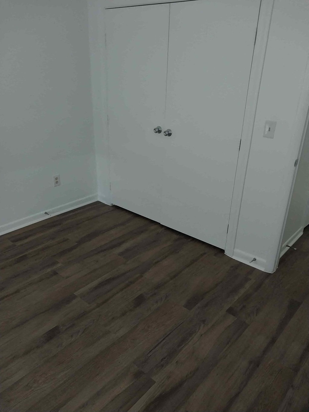 a room with a wooden floor and white doors