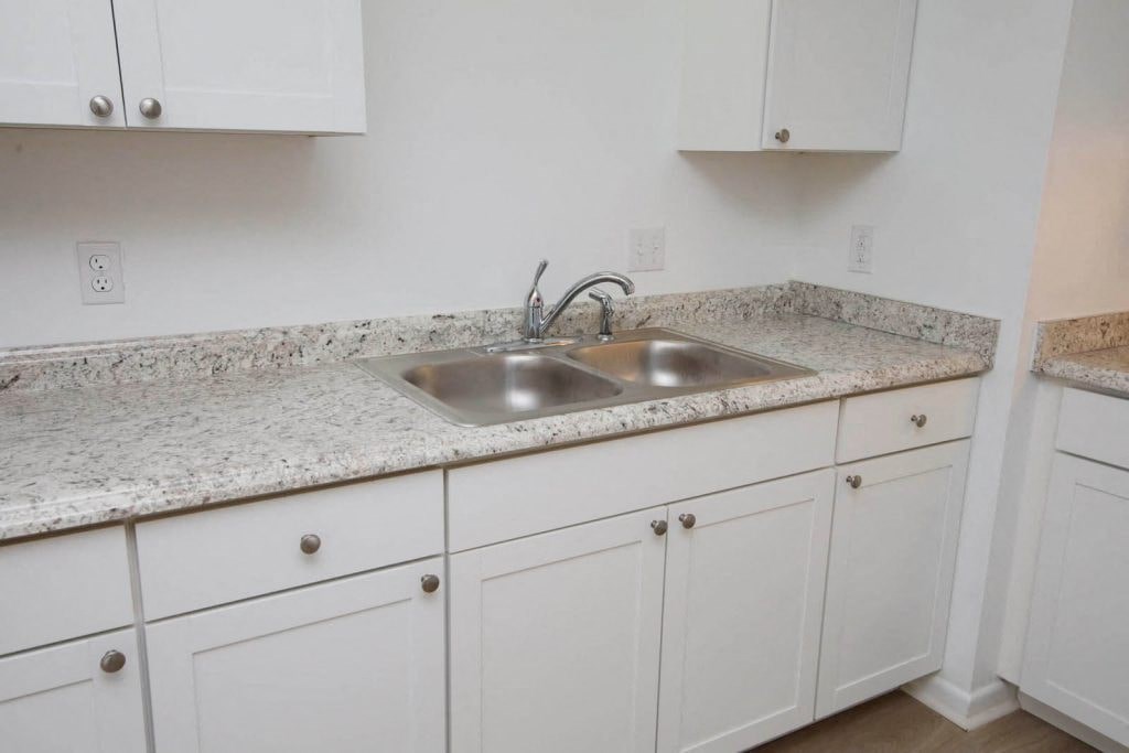 a kitchen with white cabinets and a sink