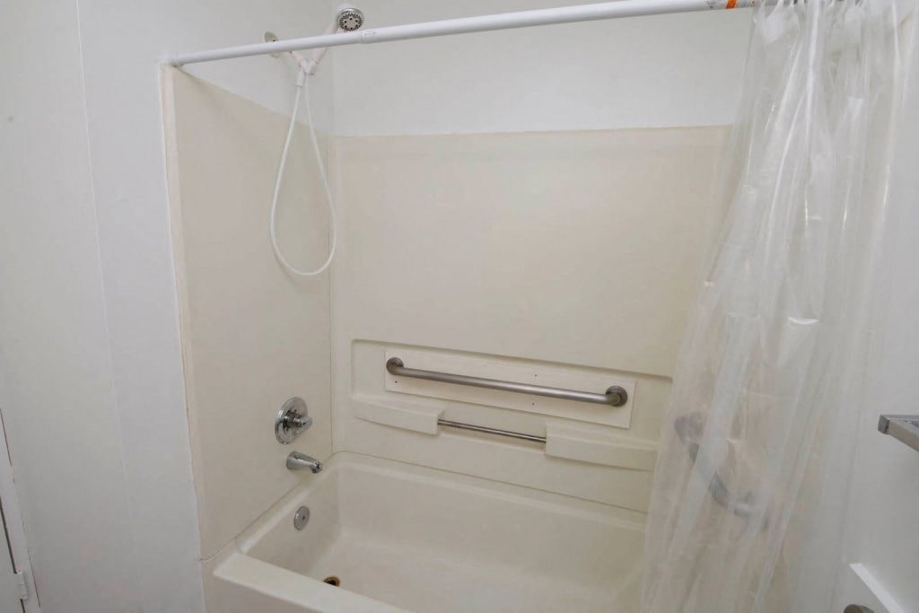 a white bathroom with a shower and a sink