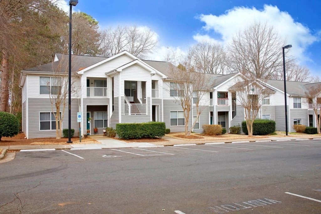 an empty parking lot in front of an apartment building