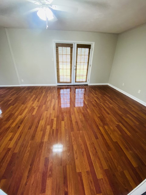 an empty living room with a hard wood floor