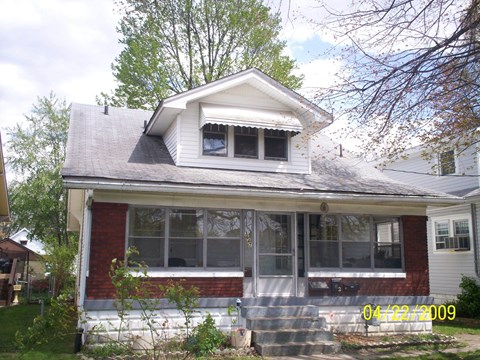 a white and brick house with a front porch