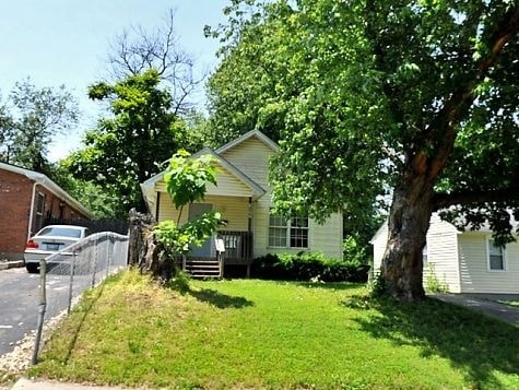 a yellow house with a tree in front of it
