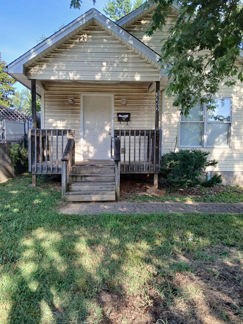 the front of a house with a porch and a wooden deck