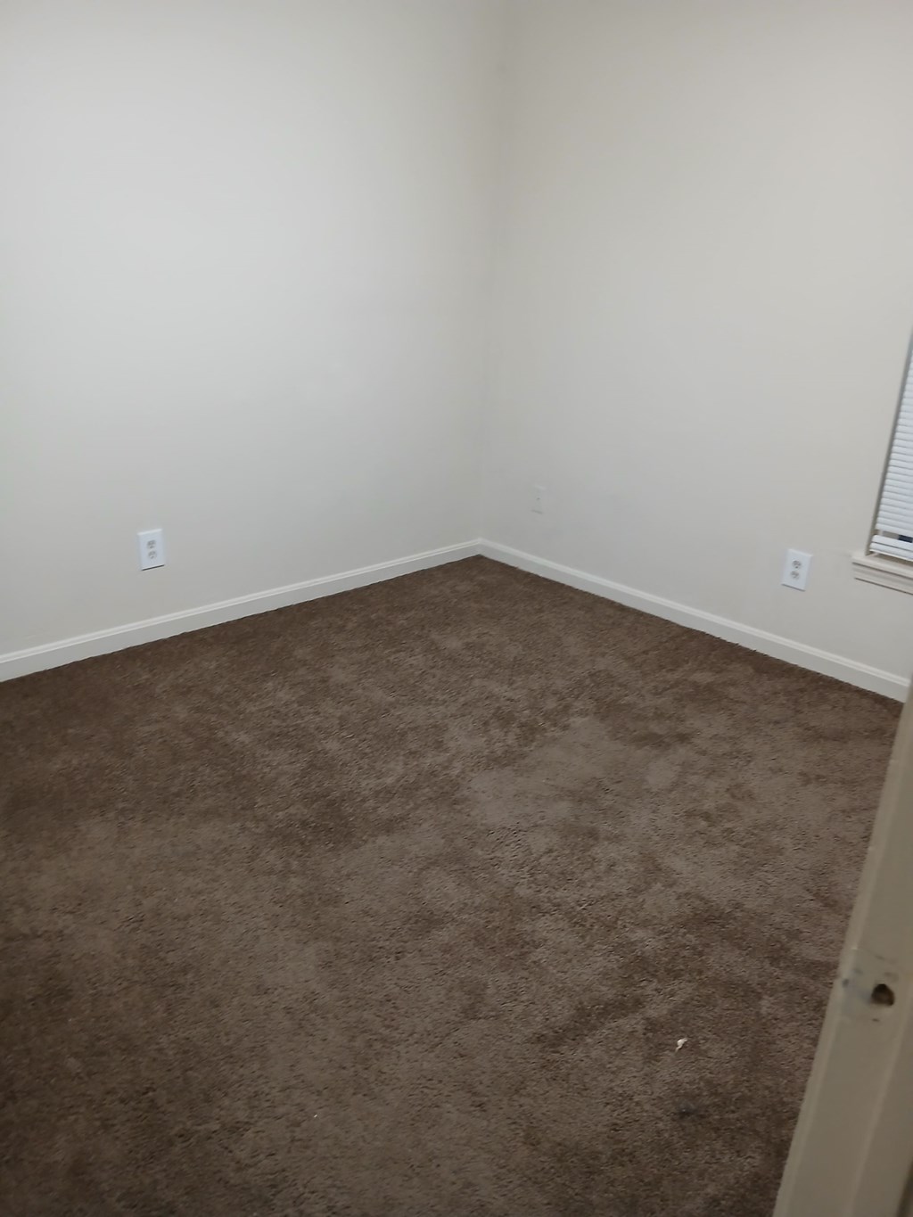 a room with a carpeted floor and a white wall