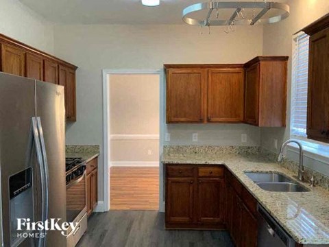 a kitchen with wooden cabinets and a stainless steel refrigerator