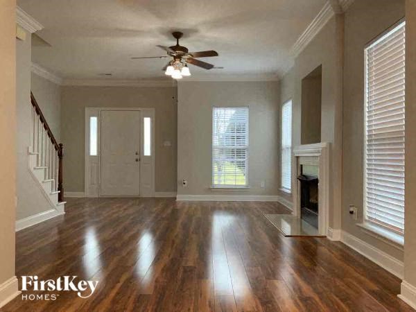 an empty living room with a ceiling fan