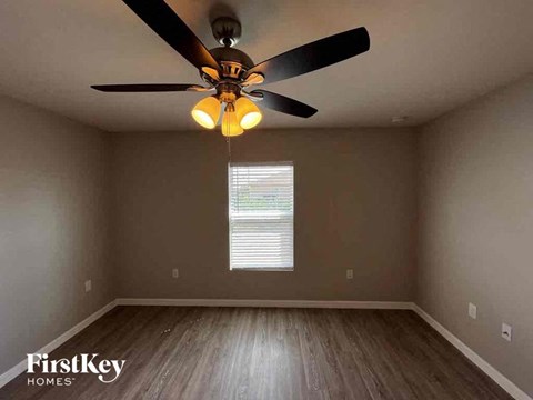 a bedroom with a ceiling fan and a window
