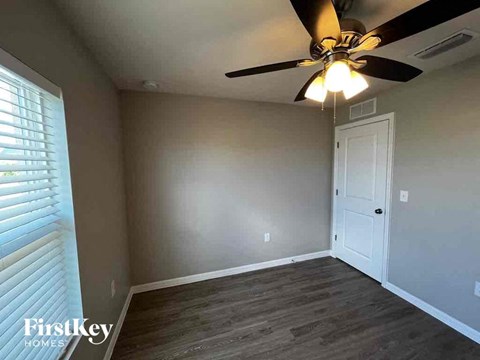 a living room with a ceiling fan and a white door