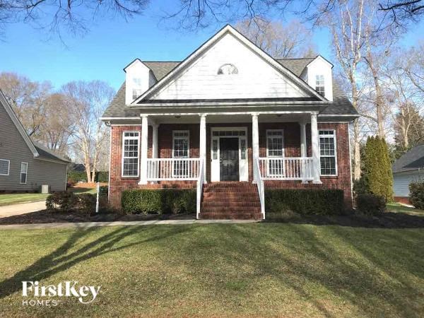 A brick house with a porch and a sign that says "FirstKey Homes".
