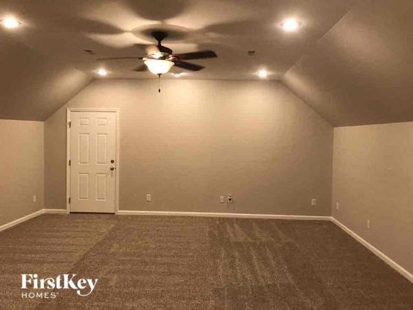 A room with a ceiling fan and a door.