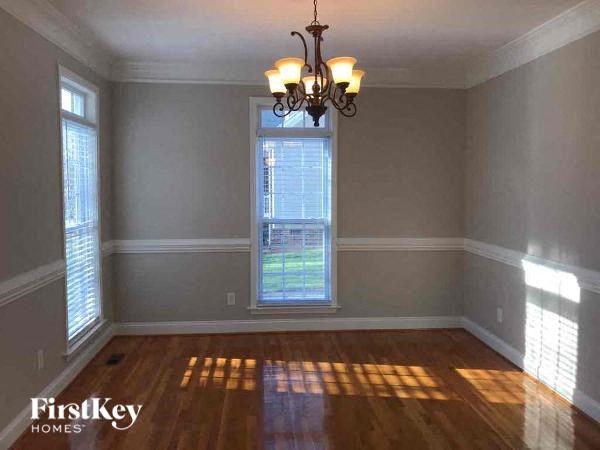 A room with wooden floors and a chandelier hanging from the ceiling.