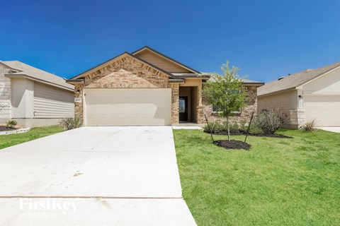 a home with a driveway and lawn in front of it
