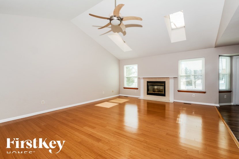 A spacious room with a fireplace and a ceiling fan.