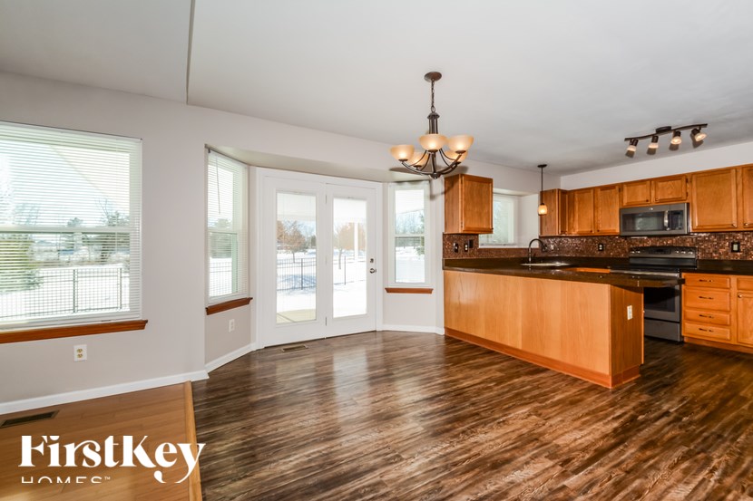 A kitchen with wooden floors and a chandelier.