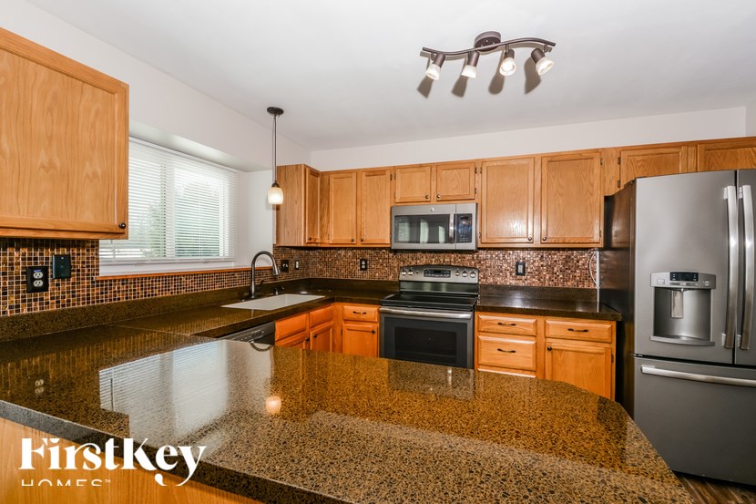 A kitchen with wooden cabinets and granite countertops.