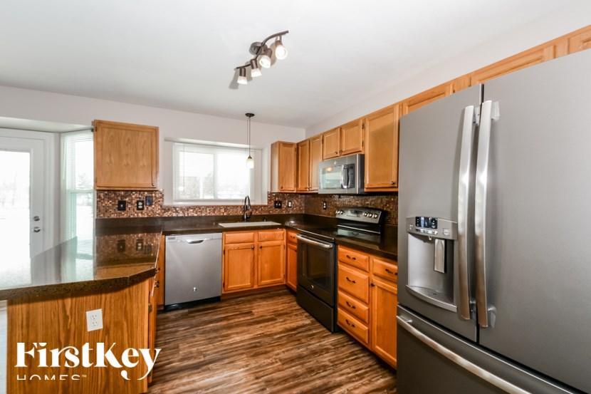 A kitchen with wooden cabinets and a refrigerator.