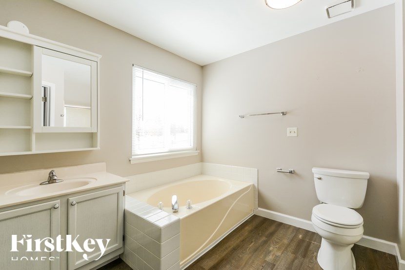 A white toilet sits next to a bathtub in a bathroom.