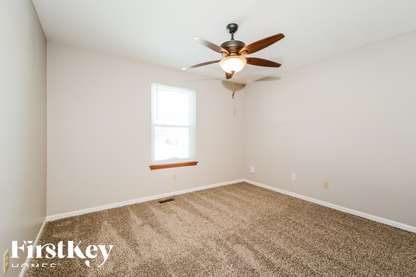 A room with a ceiling fan and a window.