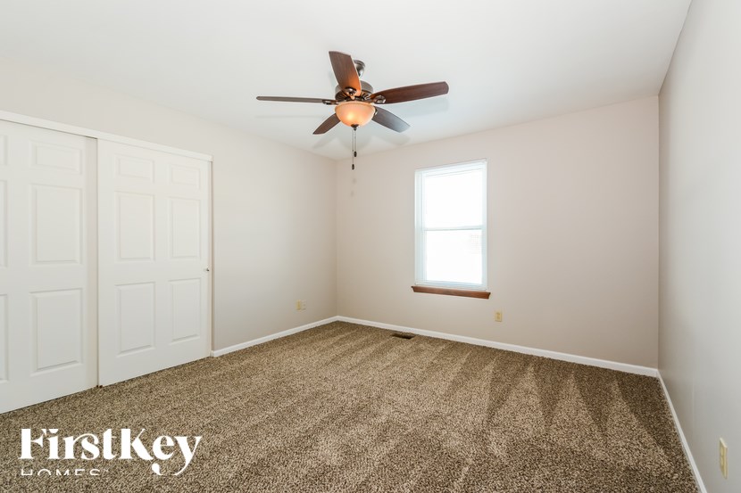 A room with a ceiling fan and a window.