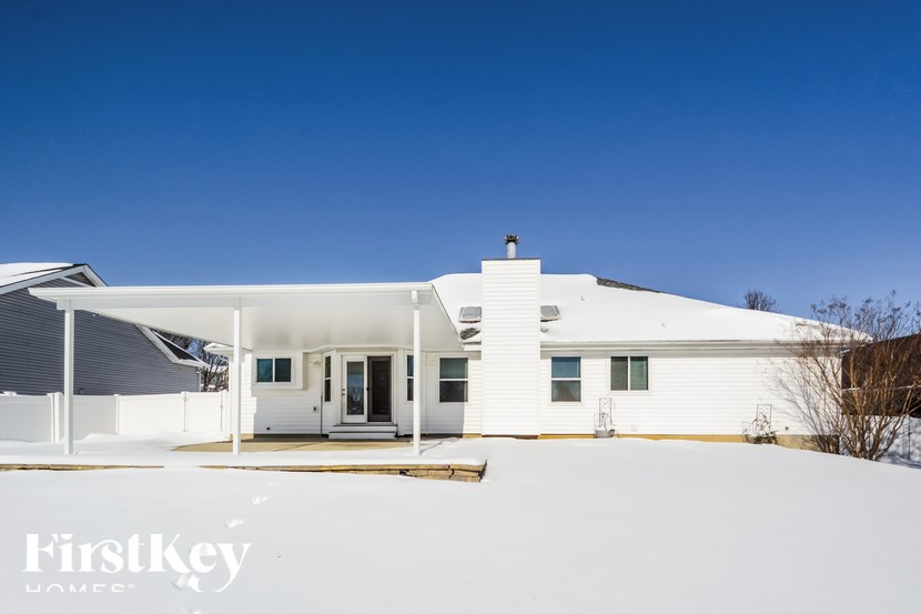 A white house with a flat roof and a chimney is shown in the image.