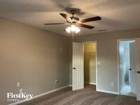 a bedroom with a ceiling fan and a door