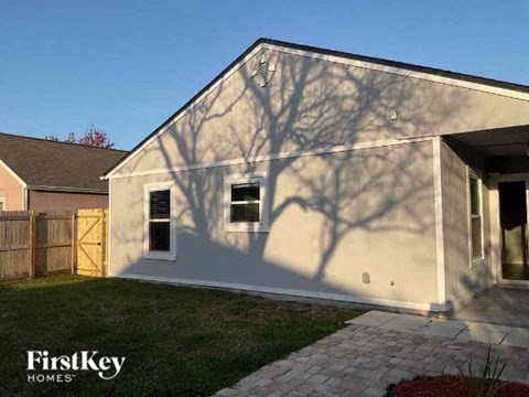 the side of a house with the shadow of a tree on it