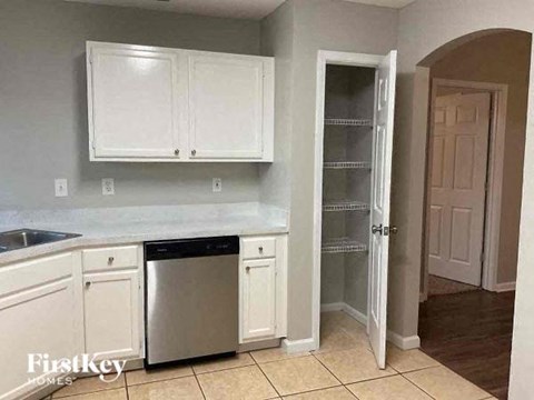 a kitchen with white cabinets and a dishwasher